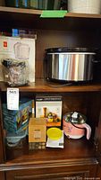 Shelf with the Crock-Pot slow cooker, PC mini chop food processor and Trellis Co. fermentation kit boxed and loose items arranged.