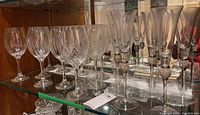 Side view of all glasses including plain wine glasses, cut wine glasses, and champagne flutes with jeweled stems.