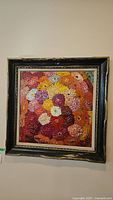 Full view of framed painting showing colorful flower bouquet and signature on bottom left.