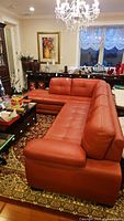 Full view of red leather L-shaped sectional couch in living room
