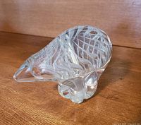 Front and side view of clear heavy glass polar bear on wood surface showing etched patterns on body.
