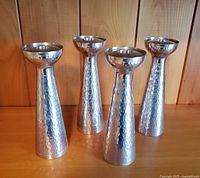 Group photo of all four pewter candle holders showing hammered texture and polished finish