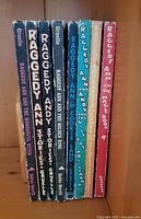 Spine view of eight vintage Raggedy Ann and Andy children's books showing titles and authorship by Gruelle