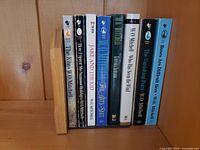 Side view of eight WO Mitchell paperback books aligned together showing spines and titles for identification