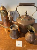 Four copper kitchen items on display: kettle, butter melter, haystack pitcher, espresso pot.