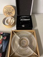 Full view of the three items showing the Arcosteel corkscrew set in box, the Petite Maison Brie baker with lid and spreader, and the glass hors d’oeuvre serving dish with wooden picks.