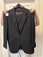 Front view of black tuxedo jacket showing overall condition and single button closure.