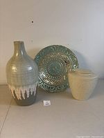 Photo showing the three decorative items including tall vase in front, teal bowl behind right, and green crackle urn with lid on left.