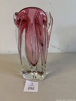 Front view of a red swirl glass vase showing its tall, thick glass form with red and clear blending.