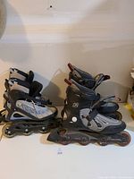 Two pairs of K2 inline roller blades, one smaller pair for women size 7 and one larger pair for men size 11, placed side by side on a flat surface.