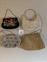 Photo of all 4 vintage handbags showing various styles: floral needlepoint, white beaded, silver sequin, gold beaded.
