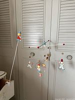 Full view of the vintage 1950s circus nursery mobile with hanging wooden figures and balance arm structure attached to crib side.