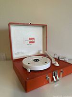 Vintage 1960s Imperial "Party Time" portable turntable open in orange casing showing white turntable platter and tonearm