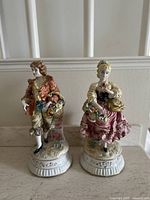 Front view of the pair of figurines showing full details of each figure and their bases.