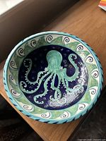 Top view showing intricate octopus and wave pattern inside the bowl in blue and teal colors.