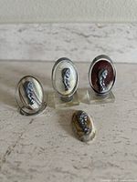 Set of four vintage Madonna and child medallions shown together on stands on a stone surface.