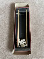 Pair of gold-colored butane candles in original box with instruction paper visible.