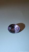 Clear view of the oval cut purple pink amethyst gemstone showing facets and internal clarity.