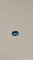 Natural oval cut Swiss Blue Topaz with deep blue color on plain background
