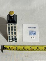 Front view of sealed ceramic house with scale showing approx 4.5 inches height.