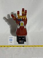 Front view of Lego Nano Gauntlet showing the colored stones on the top and mounted on the display stand.