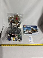 Two bags of Lego bricks and the instruction manual for the Winter Village Station set.