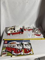 Overall view of assembled Volkswagen camper van Lego set with instruction books and loose parts.