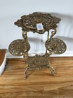 Full view of stand showing three-tier structure and ornate openwork shelves