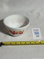 Front and side view of the white glass Pyrex mixing bowl showing red bird and yellow flower Friendship pattern.