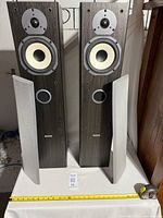 Pair of floor standing Tannoy Mercury MX3 stereo speakers with fabric grilles removed, showing drivers and bass port.