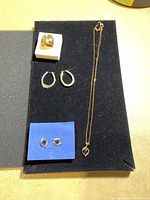 Full set laid on black velvet showing ring, two pairs of earrings, and necklace