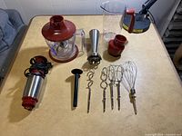 Overall lot with Wolfgang Puck hand blender parts and attachments arranged on table