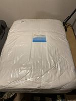 Full size mattress topper set packaged in clear plastic, white color, showing the Dream Haven label on top.