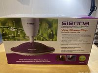 Side view of the Sienna Vibe Steam Mop box showing product image, branding, and key features including 1500 Watt steam power, safe for sealed hard floor surfaces, and eco-friendly cleaning.