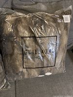 Single faux fur throw pillow in sealed clear plastic bag, displaying Guillaume Home branding and product tags.