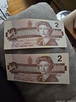 Front side of two Canadian $2 banknotes featuring Queen Elizabeth II portrait and denomination '2 CANADA'.