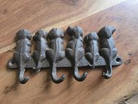 Top-down view of the cast iron dog tails key holder showing five hooks shaped like dog tails and mounting holes on each end.