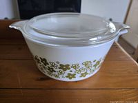 Vintage Pyrex opaque white milk glass casserole dish with green floral pattern and clear glass lid