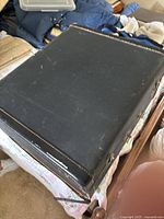 Closed black textured hard shell case showing wear and metal latches