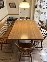 Wooden dining table with several matching chairs around it, showing overall style and color of chairs.