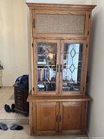 Front view of oak wood hutch with leaded glass doors on upper cabinet and two wood doors on lower cabinet