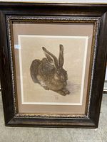 Full view of framed print showing the detailed image of the 'Young Hare' seated, framed in dark wood with inner decorative trim and glass cover.