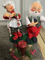 Both Annalee Santa and Mrs. Claus figurines standing side by side with candle centerpiece in front