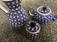 Pitcher, teapot, and sugar container together showing overall set and pattern details
