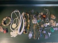 Overview of all jewelry items spread on dark surface