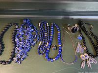 Overall view of all jewelry pieces on dark green surface