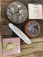 Photo of assorted rabbit-themed decorative and kitchen items including wall clock, wall plaque, decorative plate, treat boxes and a white ceramic dish on a wooden surface.