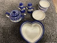 Full set showing teapot, six bowls, heart dish, and two figurines arranged on carpeted surface.