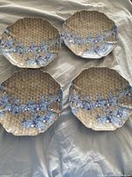 Four octagonal Fitz and Floyd plates with gold geometric textured background and blue and white Japanese horsemen design.