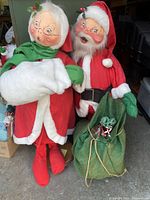 Photo showing both Santa Claus and Mrs. Claus Annalee vintage figures together in full view, highlighting their clothing and facial features.